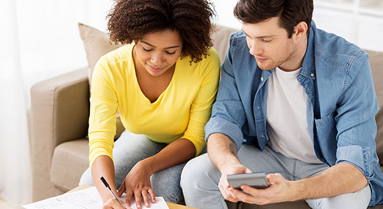 thumbnailfor Young couple sitting on the couch looking over finances