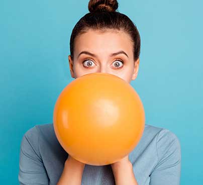 Woman inflating an orange balloon